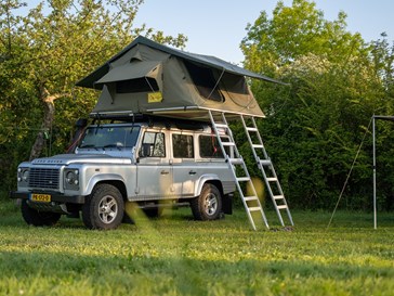 Kamperen in een daktent op een Land Rover Defender Kamperen in een daktent op een Land Rover Defender