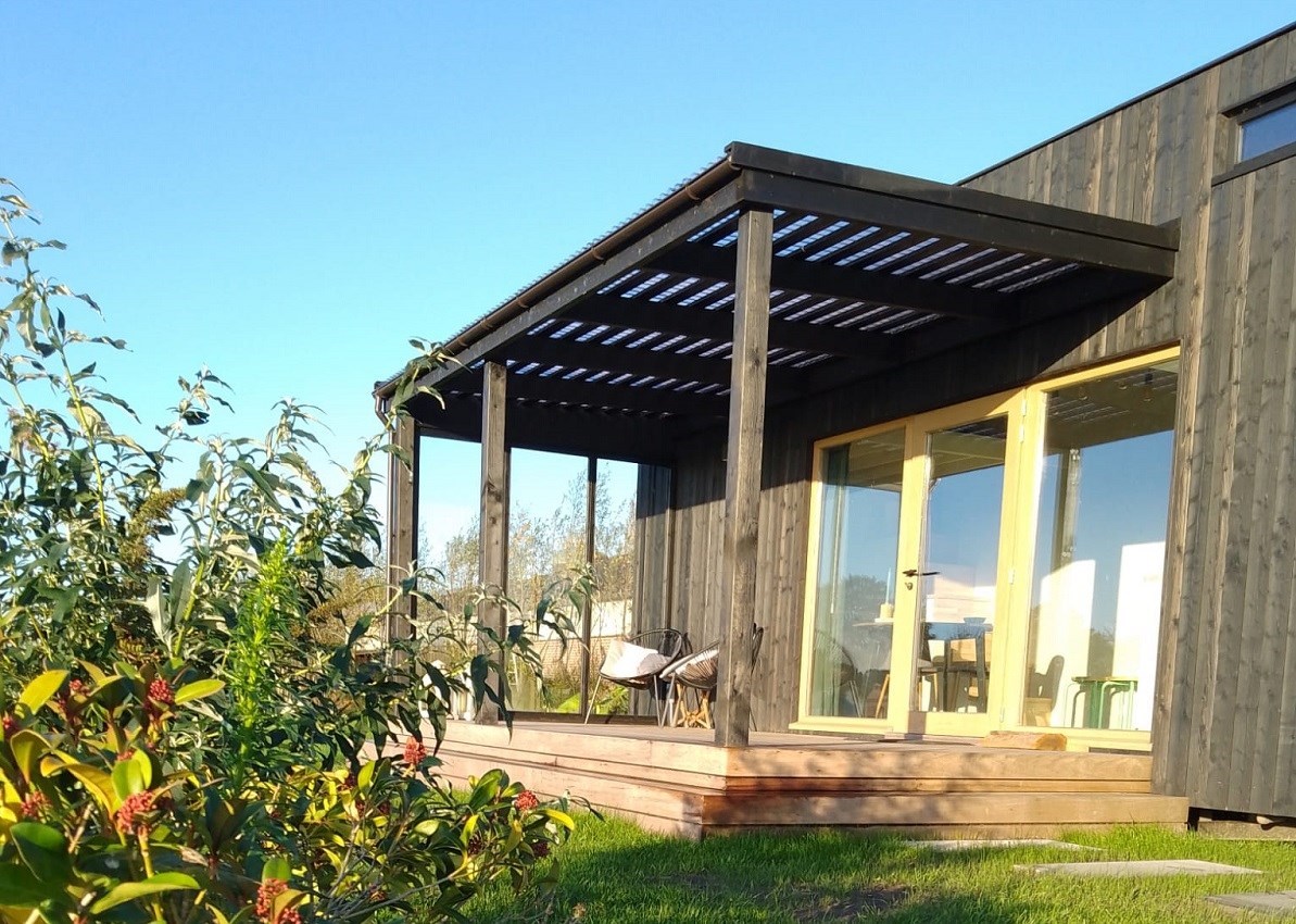 Tiny house met overdekt terras en een weids uitzicht over de weilanden