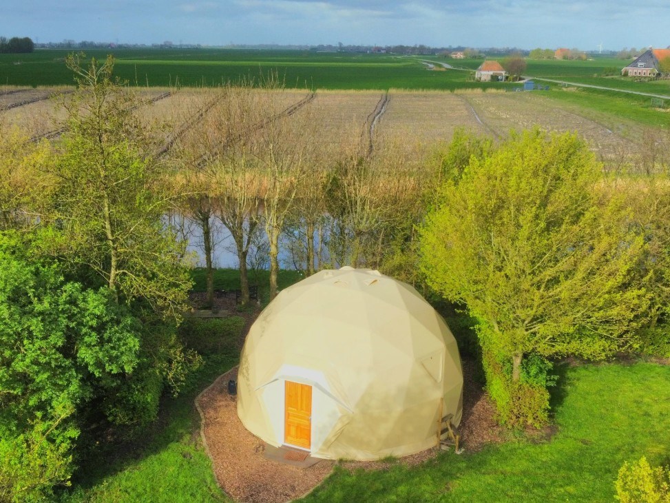 Dome met uitzicht over de weilanden en het water