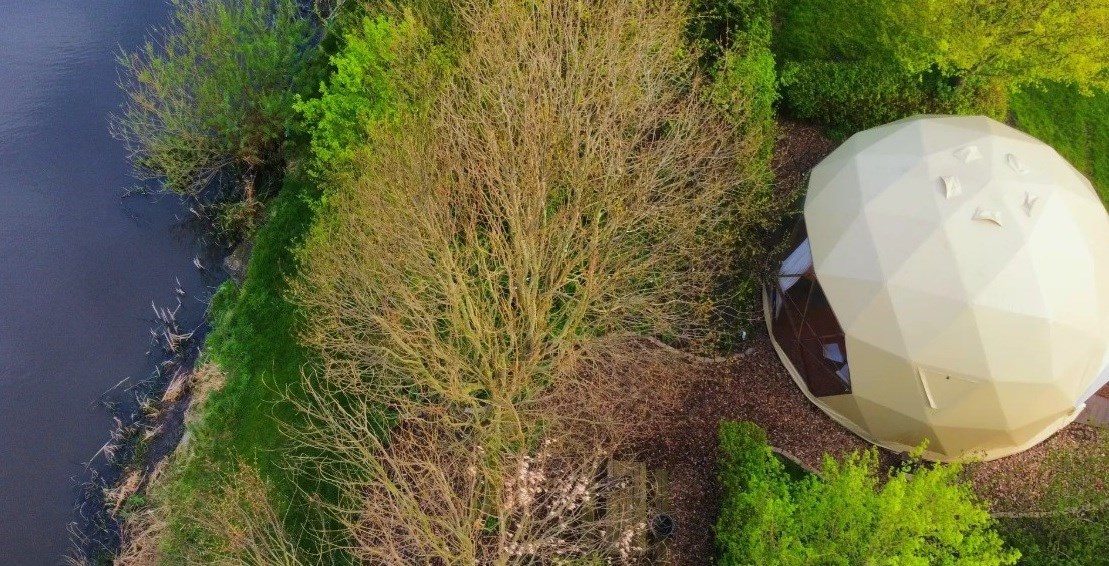Dome met uitzicht over de weilanden en het water