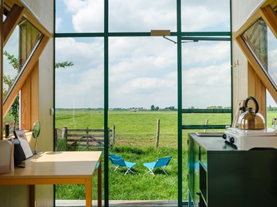 Eindeloos turen over de polder door de grote glazen wand van deze unieke hut Eindeloos turen over de polder door de grote glazen wand van deze unieke hut