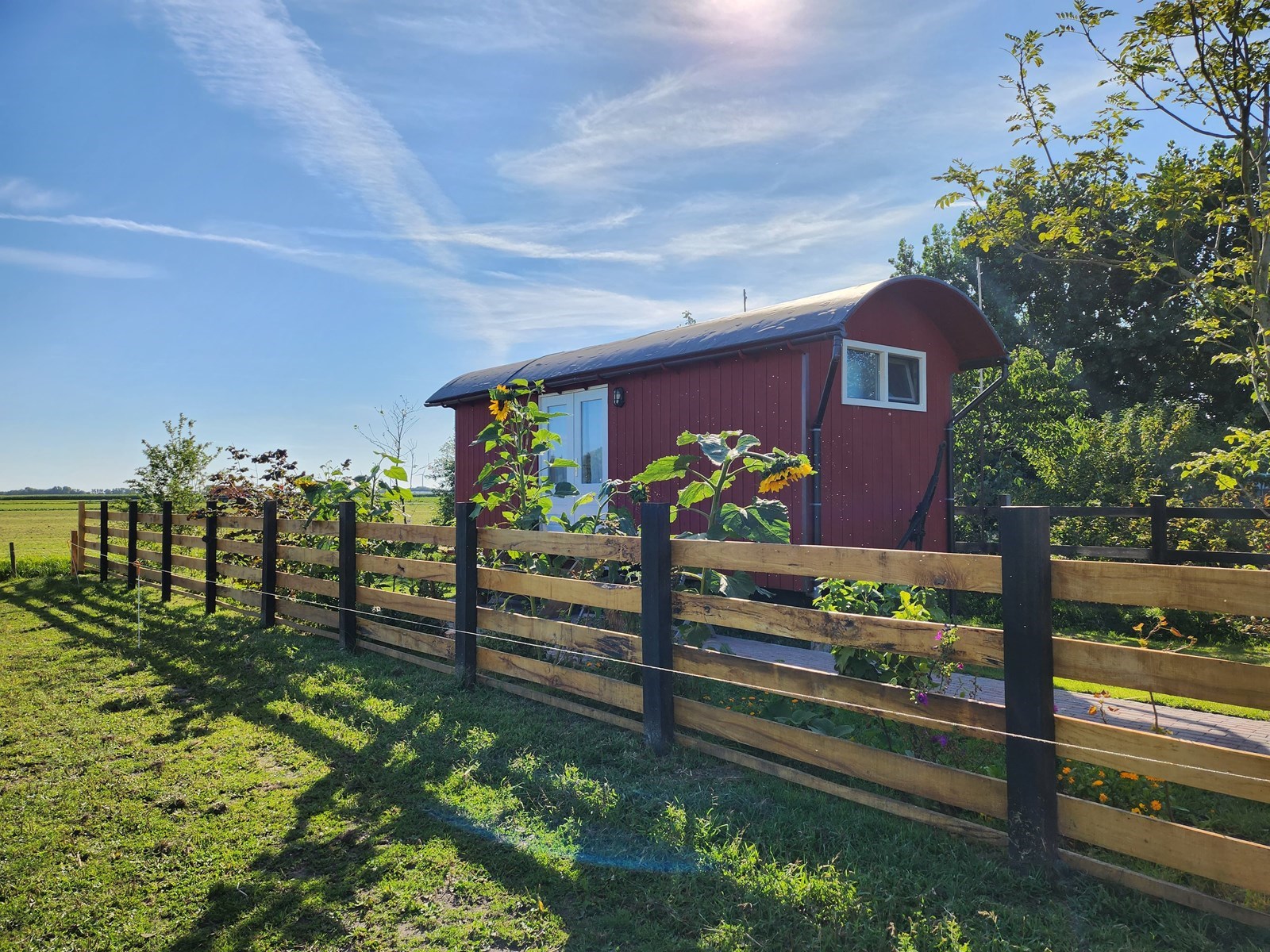 Pipowagen aan de rand van een boerenerf met vrij uitzicht