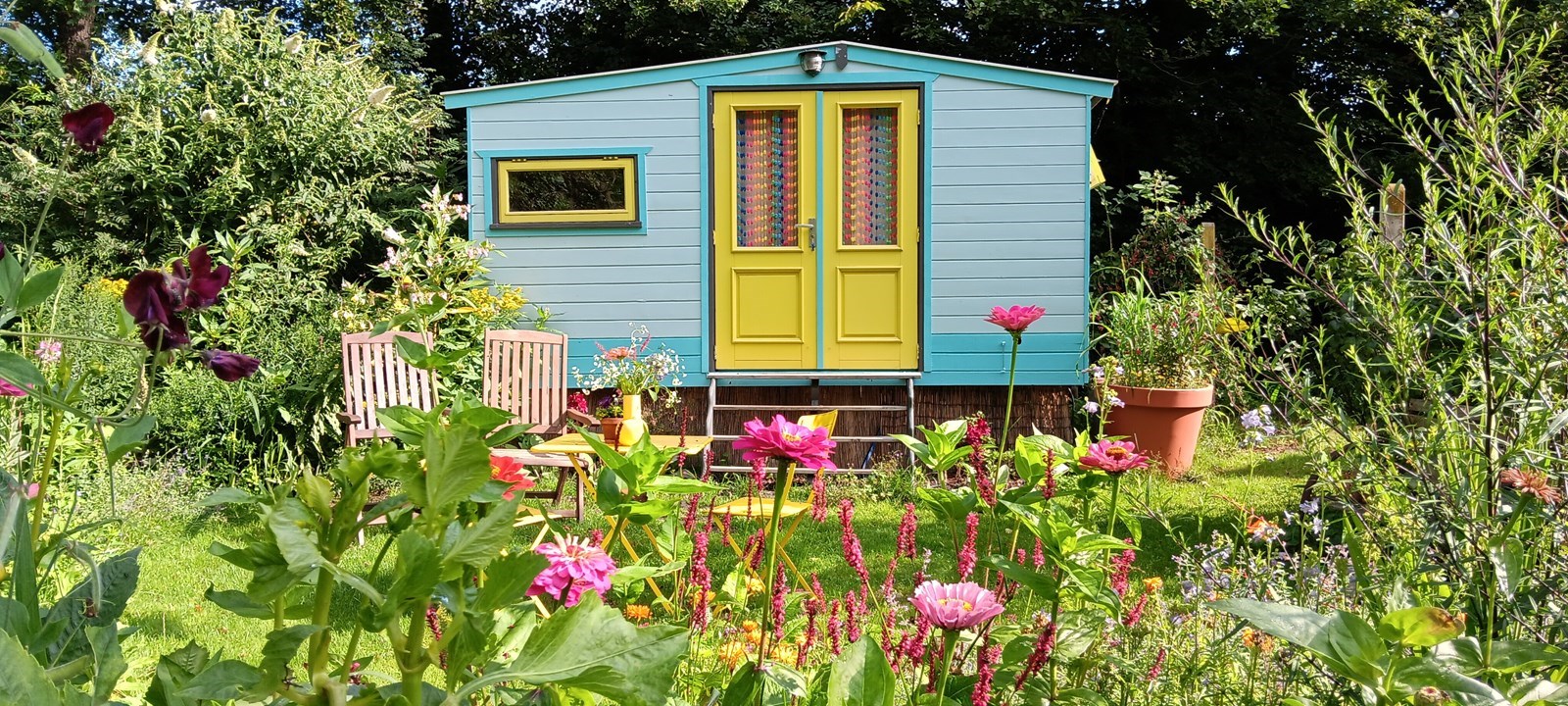 Knusse Pipowagen midden in de moestuin