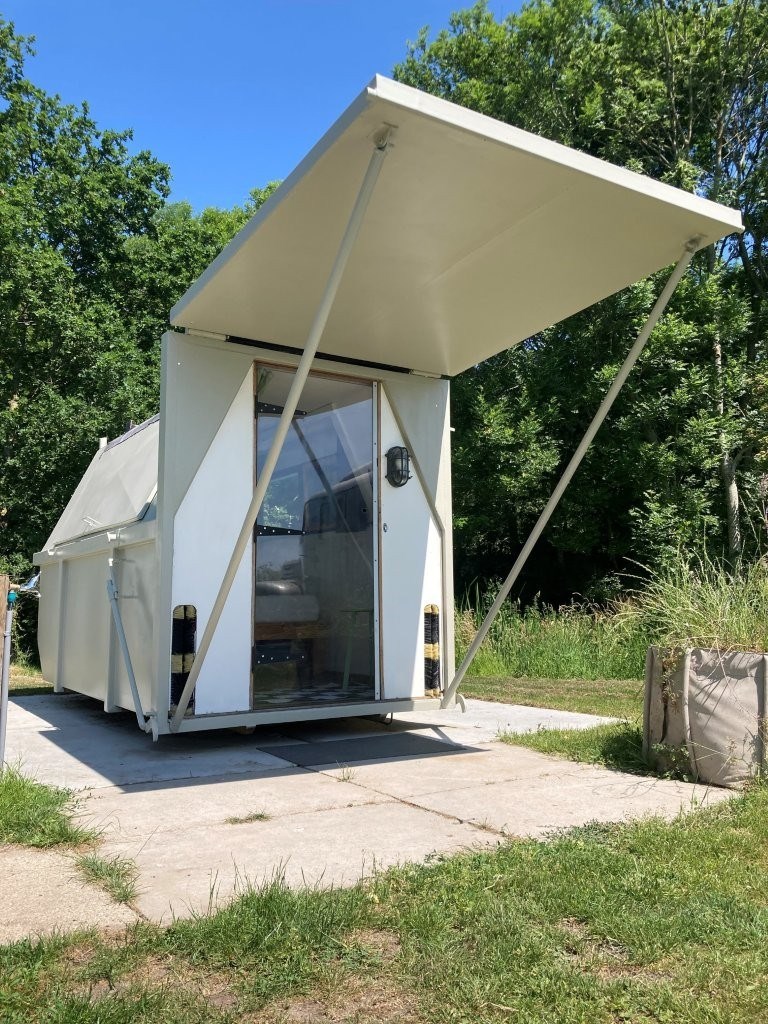 Origineel overnachten in een oude afvalcontainer van staal