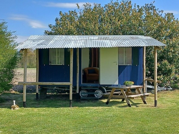 Bijzondere blauwe woonwagen die doet denken aan een Australische cottage